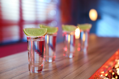 Photo of Mexican Tequila with salt and lime slices on bar counter. Space for text