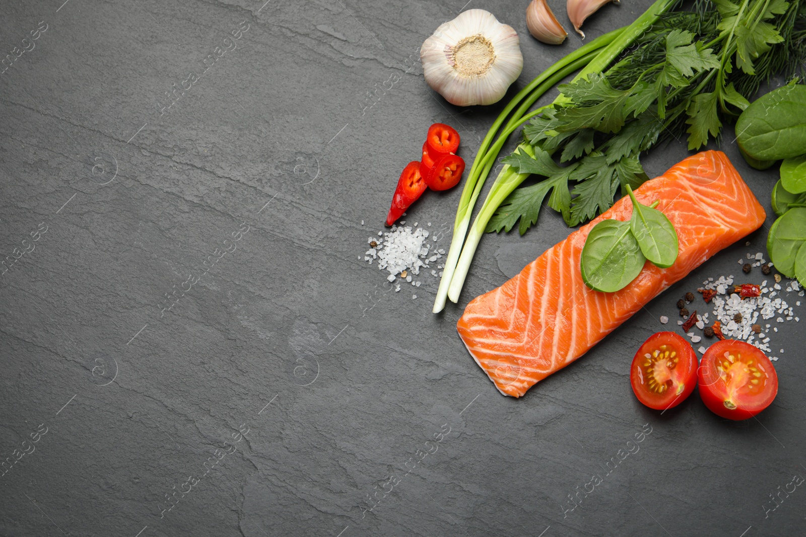 Photo of Fresh salmon and ingredients for marinade on black table, flat lay. Space for text