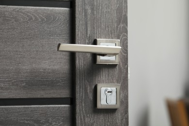 Open wooden door with metal handle, closeup