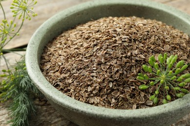 Dry seeds and fresh dill on wooden table, closeup