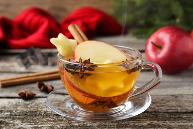 Photo of Hot mulled cider on wooden table, closeup