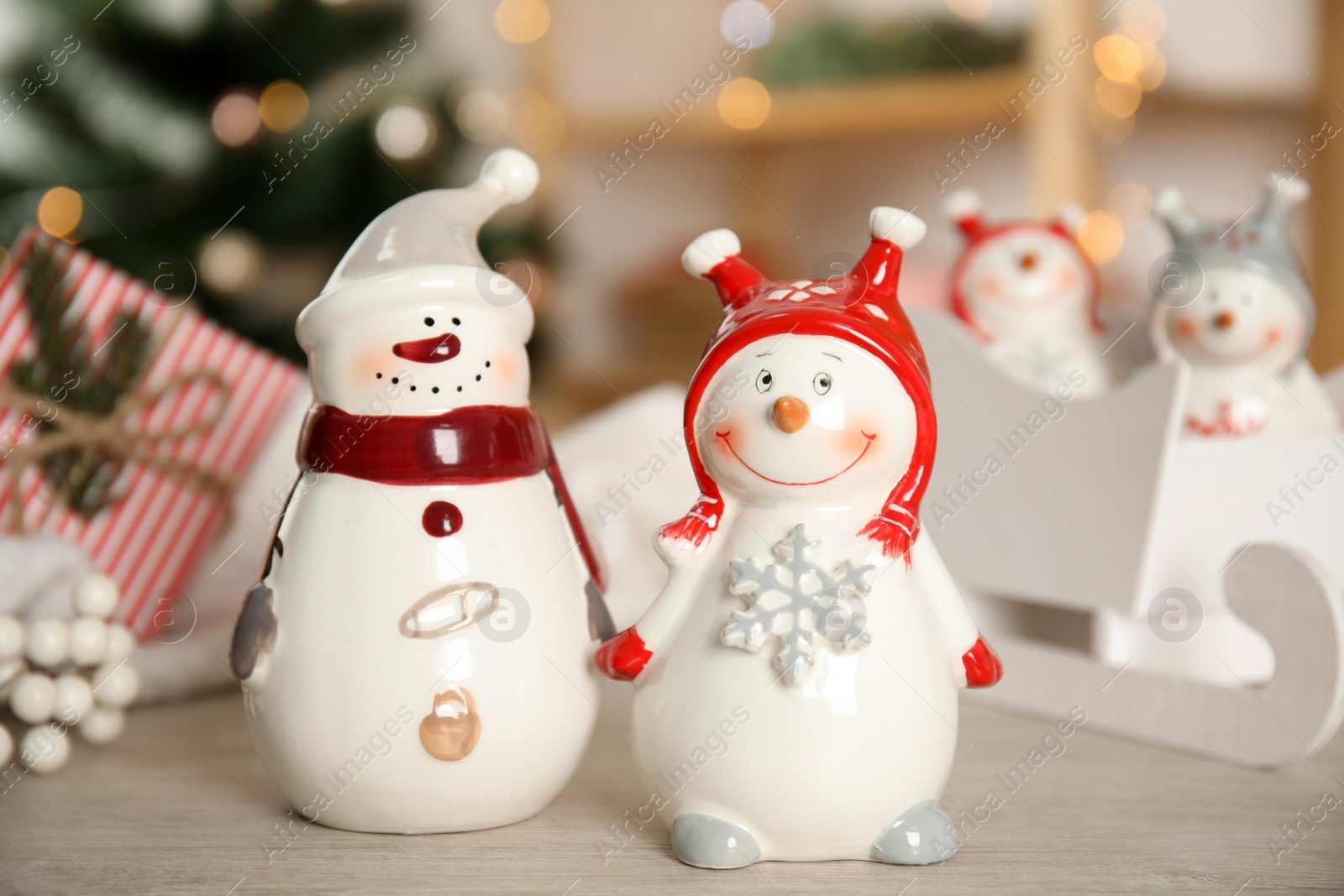 Photo of Cute decorative snowmen on table against blurred background