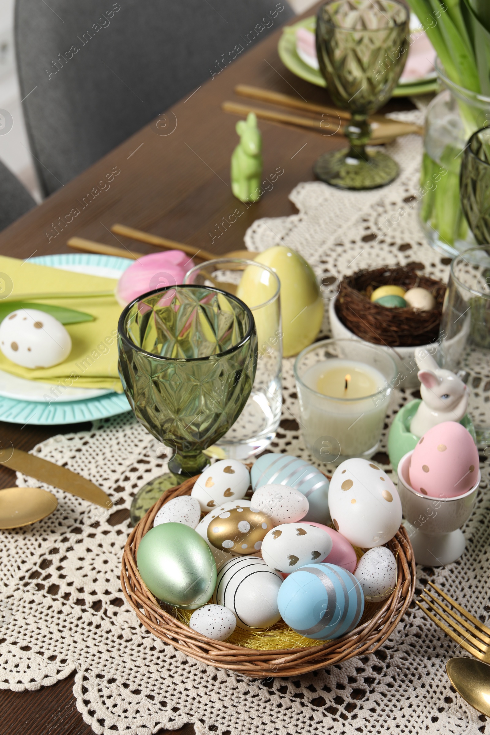 Photo of Festive table setting with painted eggs. Easter celebration