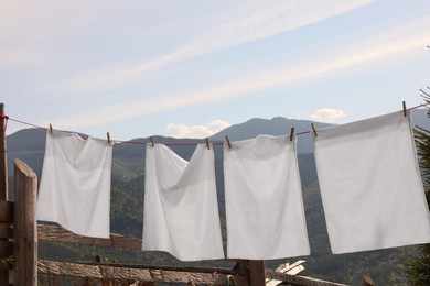 Photo of Laundry with clothes pins on line outdoors