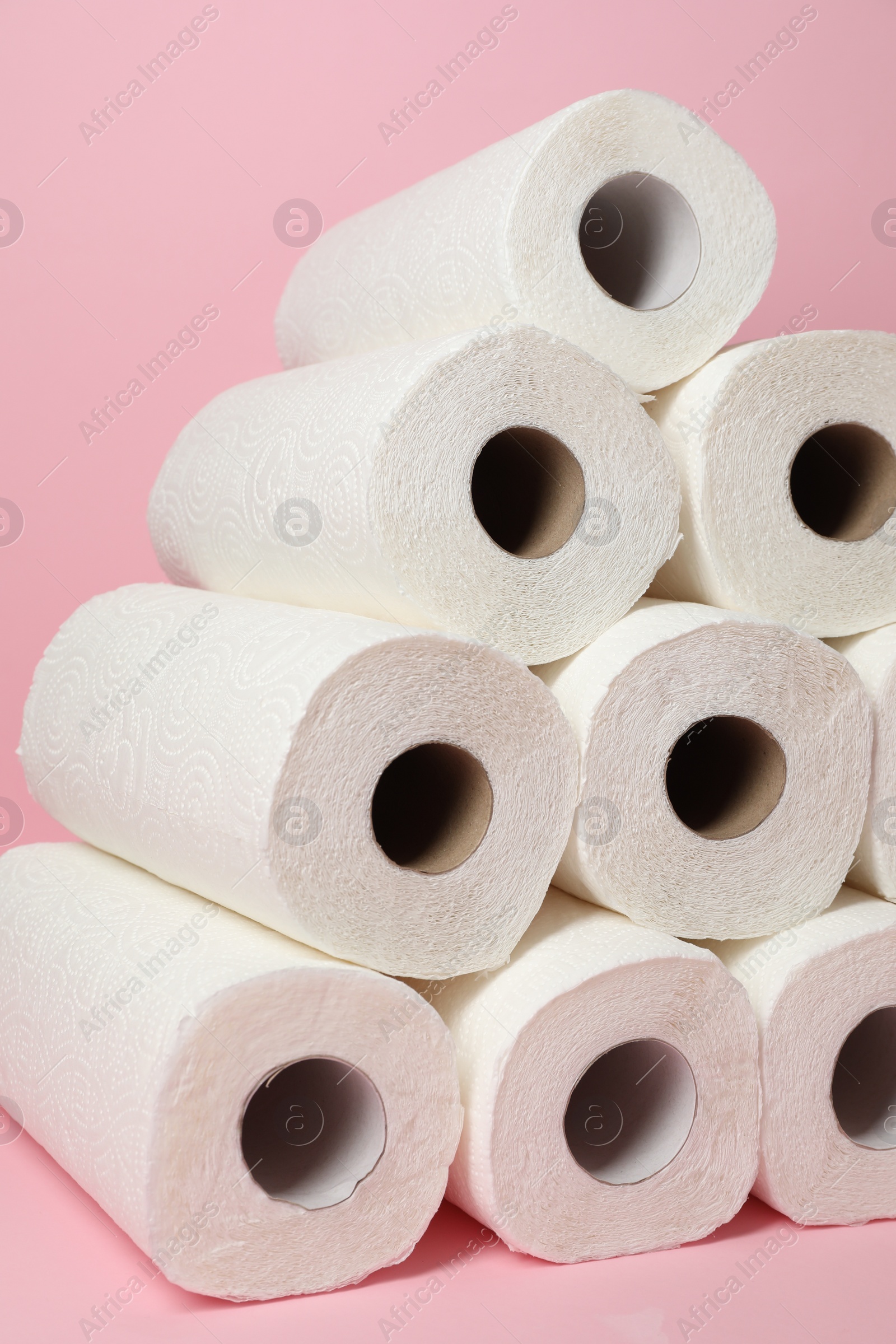Photo of Many rolls of paper towels on pink background