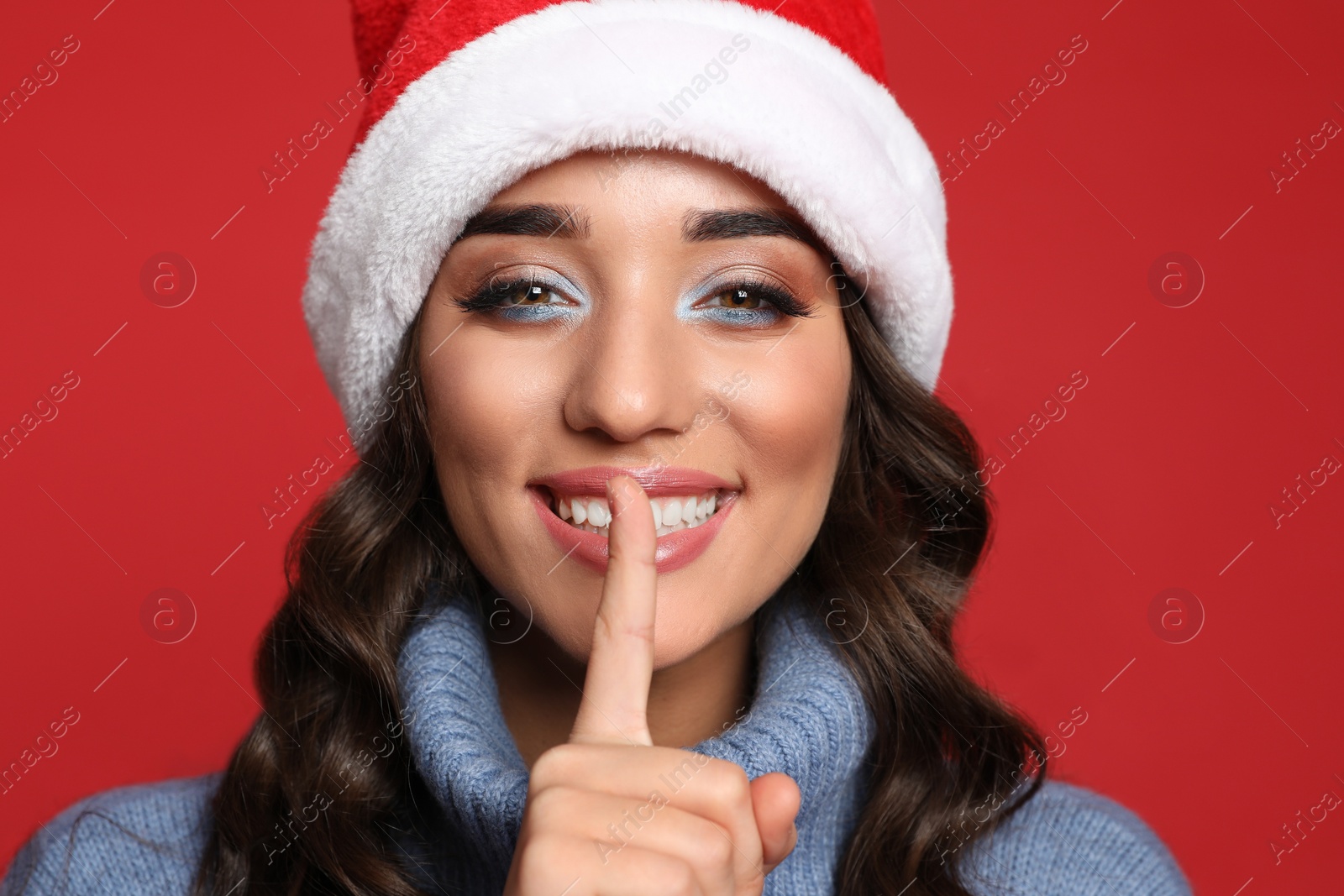 Photo of Beautiful woman in Santa hat on red background. Christmas party