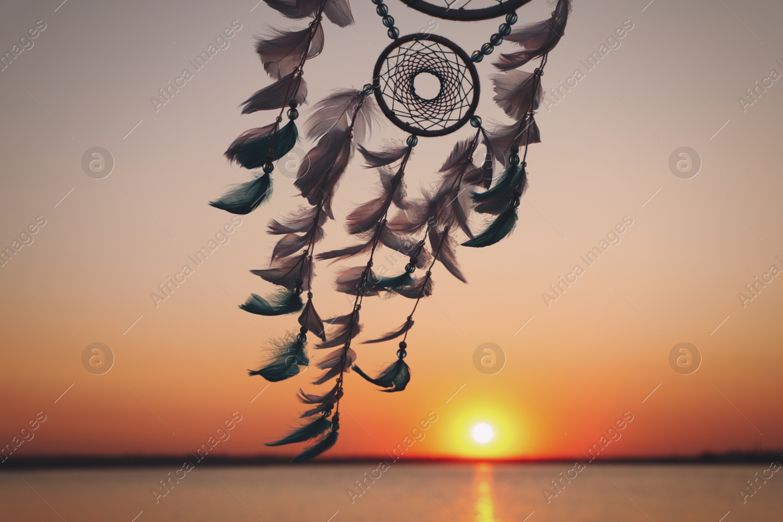 Photo of Beautiful handmade dream catcher near river at sunset