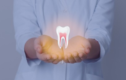 Image of Dentist showing virtual model of tooth on grey background, closeup
