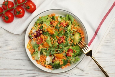 Delicious salad with lentils and vegetables served on white wooden table, flat lay