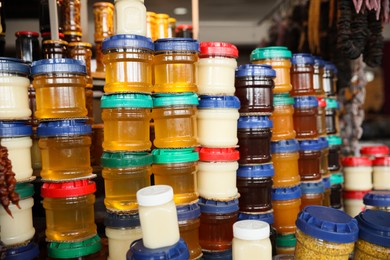 Photo of Jars with aromatic honey and different jams at market