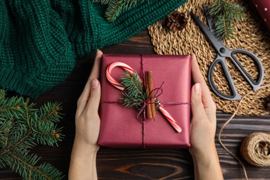 Photo of Woman with gift box at wooden table, top view