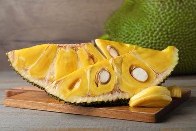 Photo of Slices of delicious exotic jackfruit on wooden table