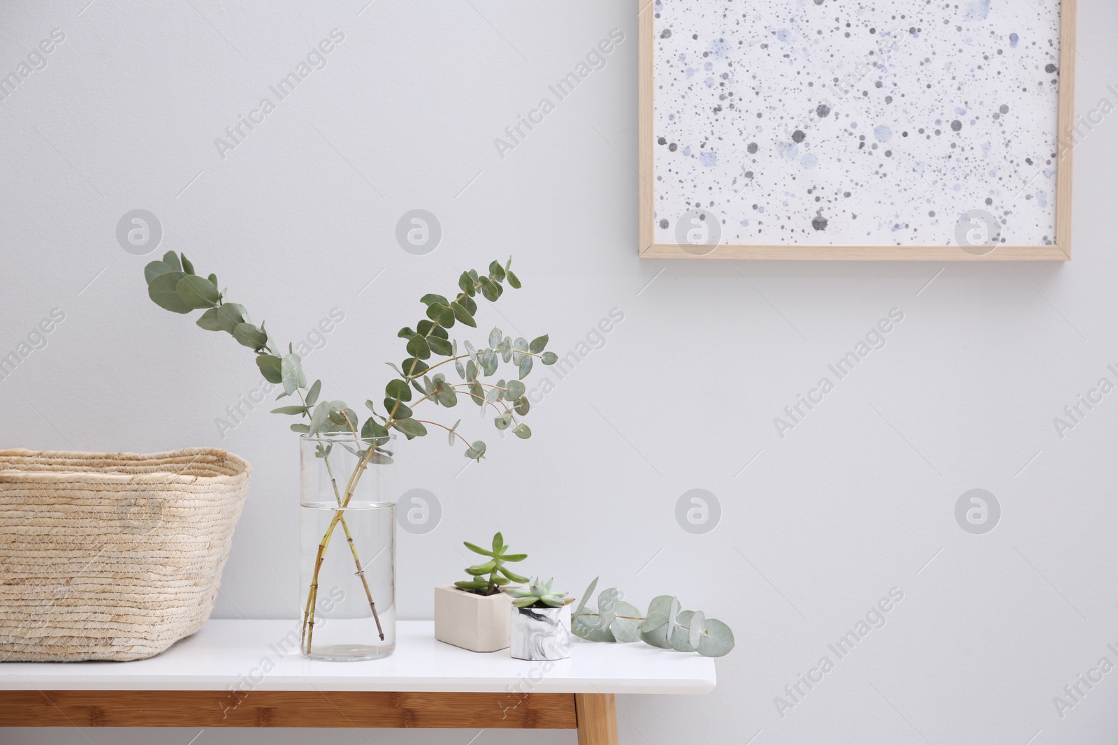 Photo of Vase with fresh eucalyptus branches on table in room. Interior design