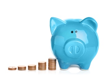 Photo of Ceramic piggy bank and many coins on white background