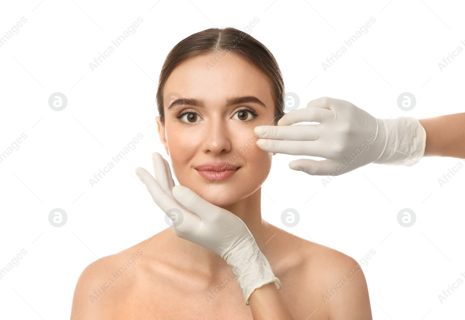 Photo of Doctor examining woman's face before plastic surgery on white background