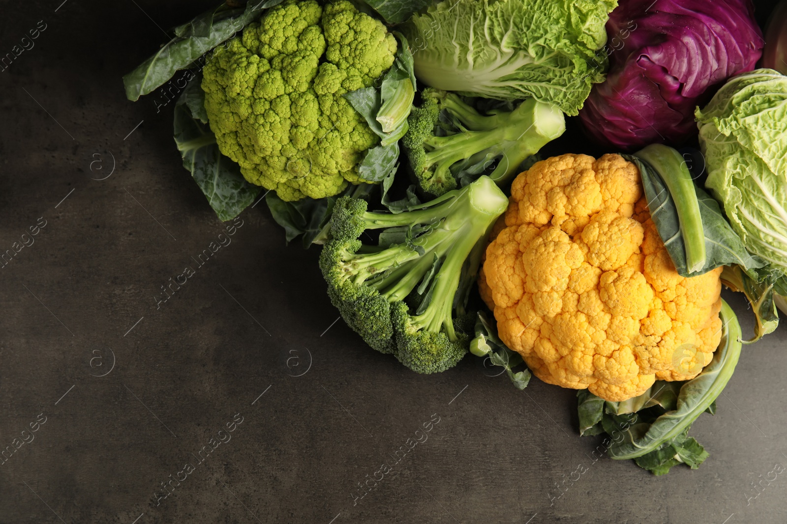 Photo of Different fresh cabbages on table, top view. Healthy food