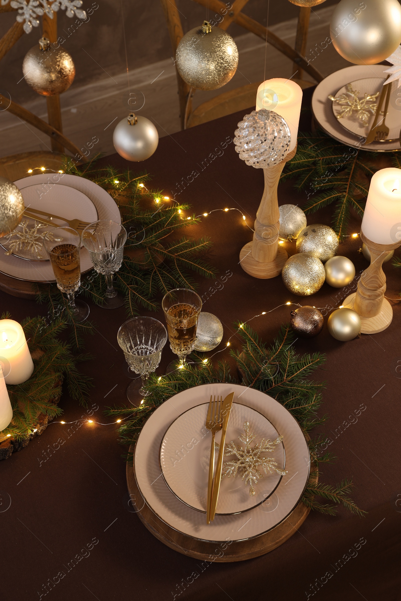 Photo of Christmas table setting with burning candles and festive decor