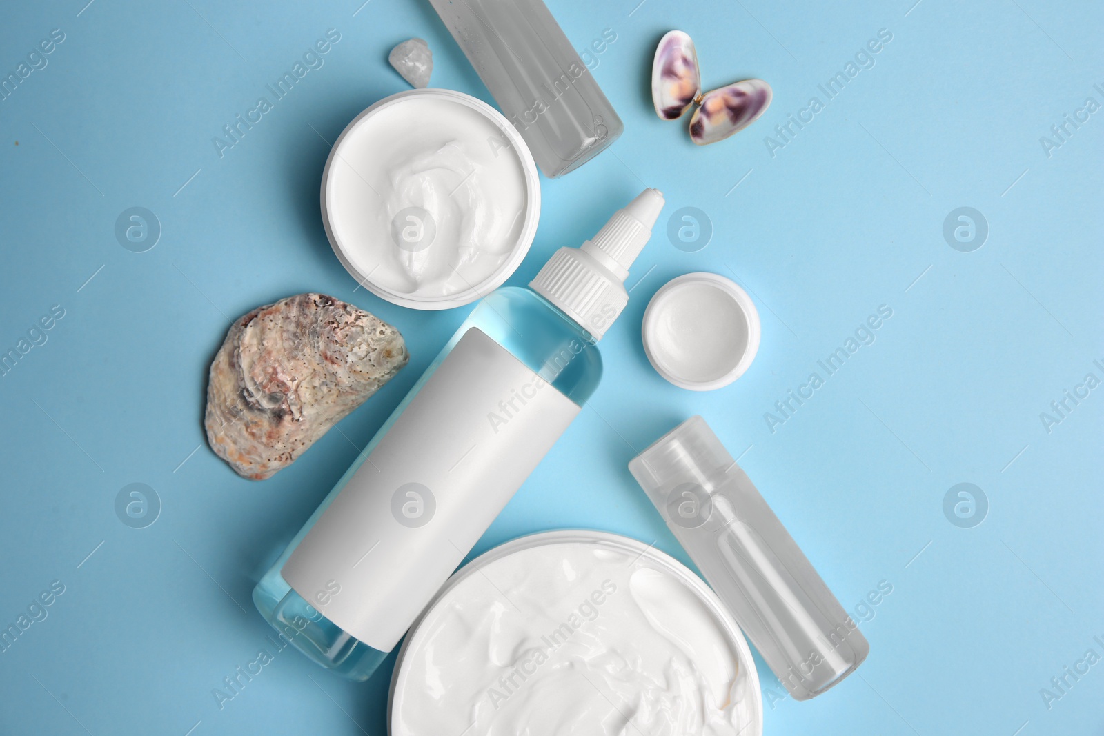 Photo of Flat lay composition with different cosmetic products on light blue background