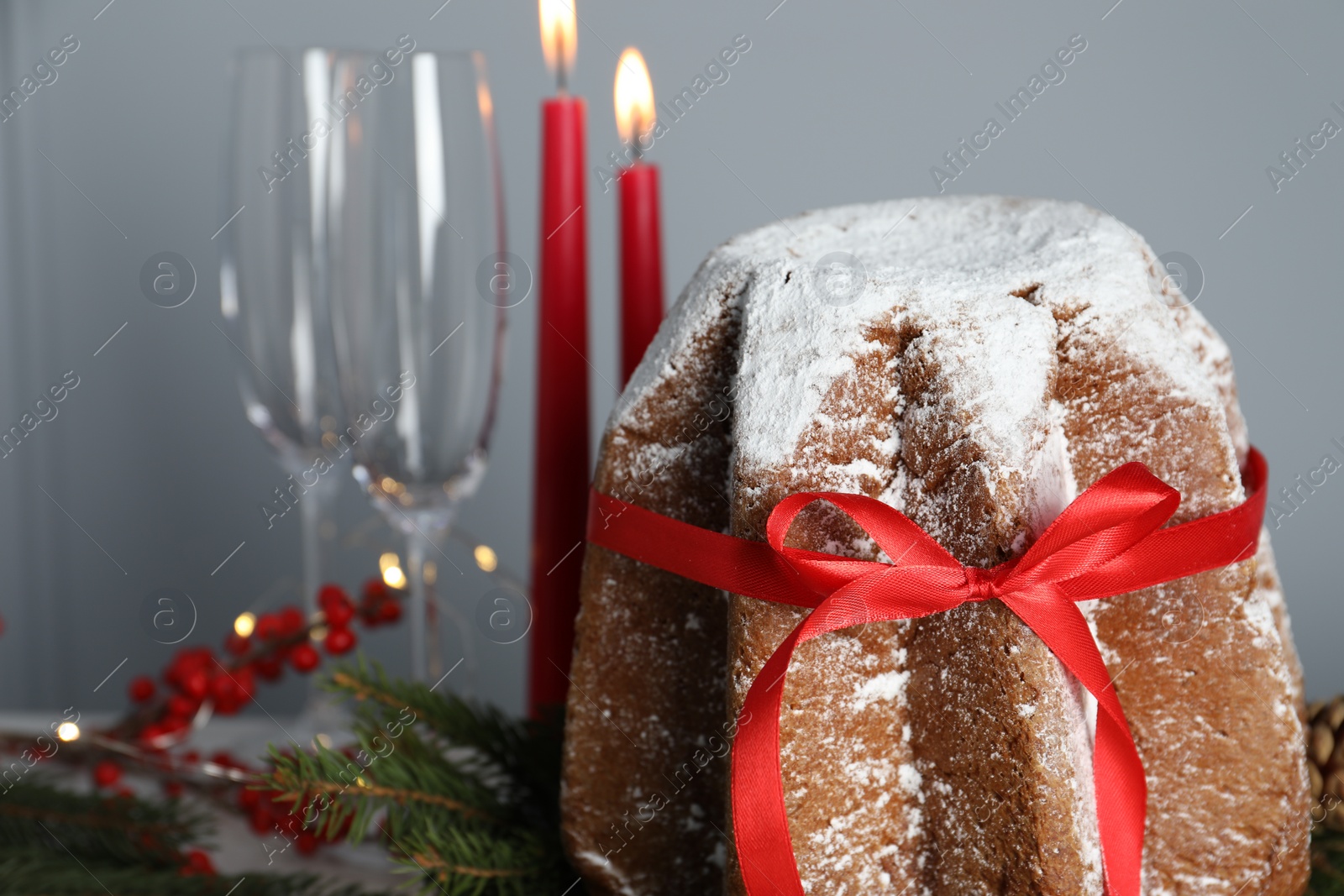Photo of Delicious Pandoro cake with powdered sugar and Christmas festive decor against grey wall, space for text. Traditional Italian pastry