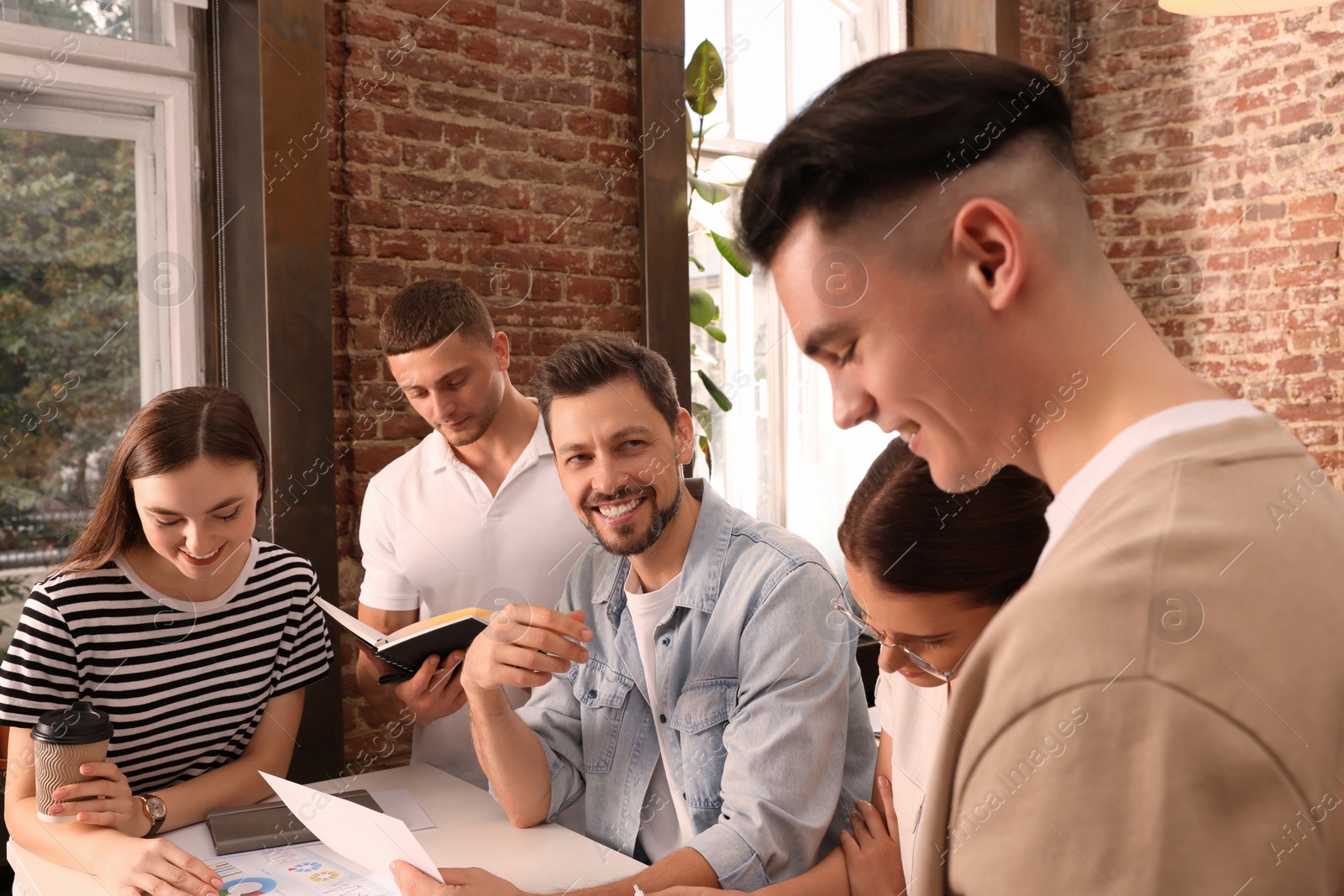 Photo of Team of employees working together in office