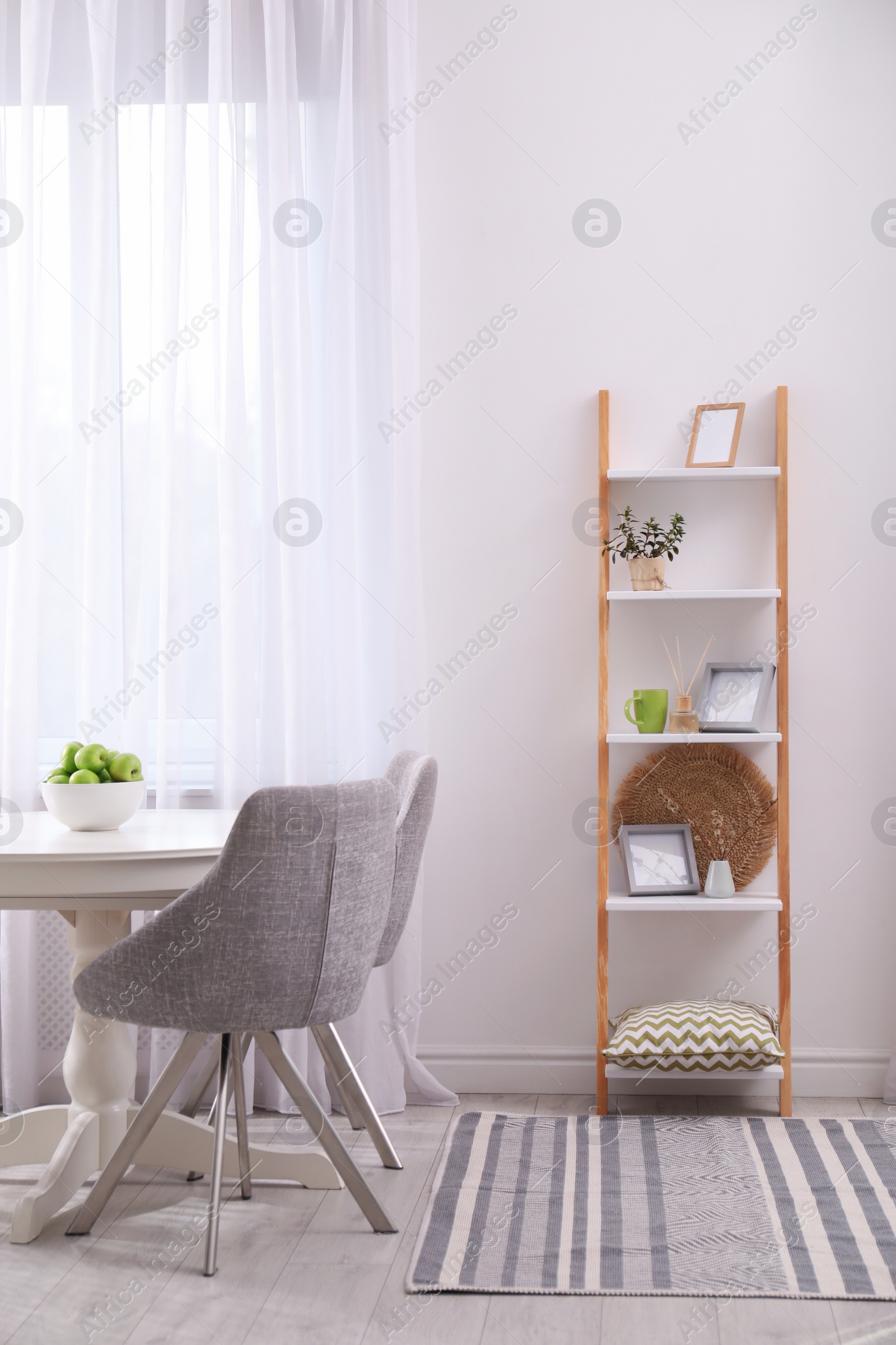 Photo of Stylish living room interior with wooden ladder near white wall