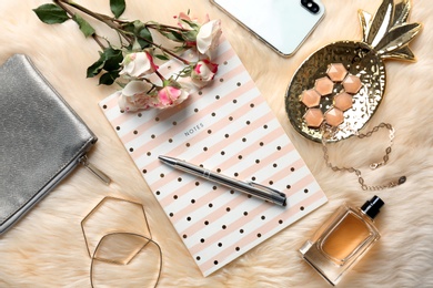 Flat lay composition with notebook and stylish accessories on fur