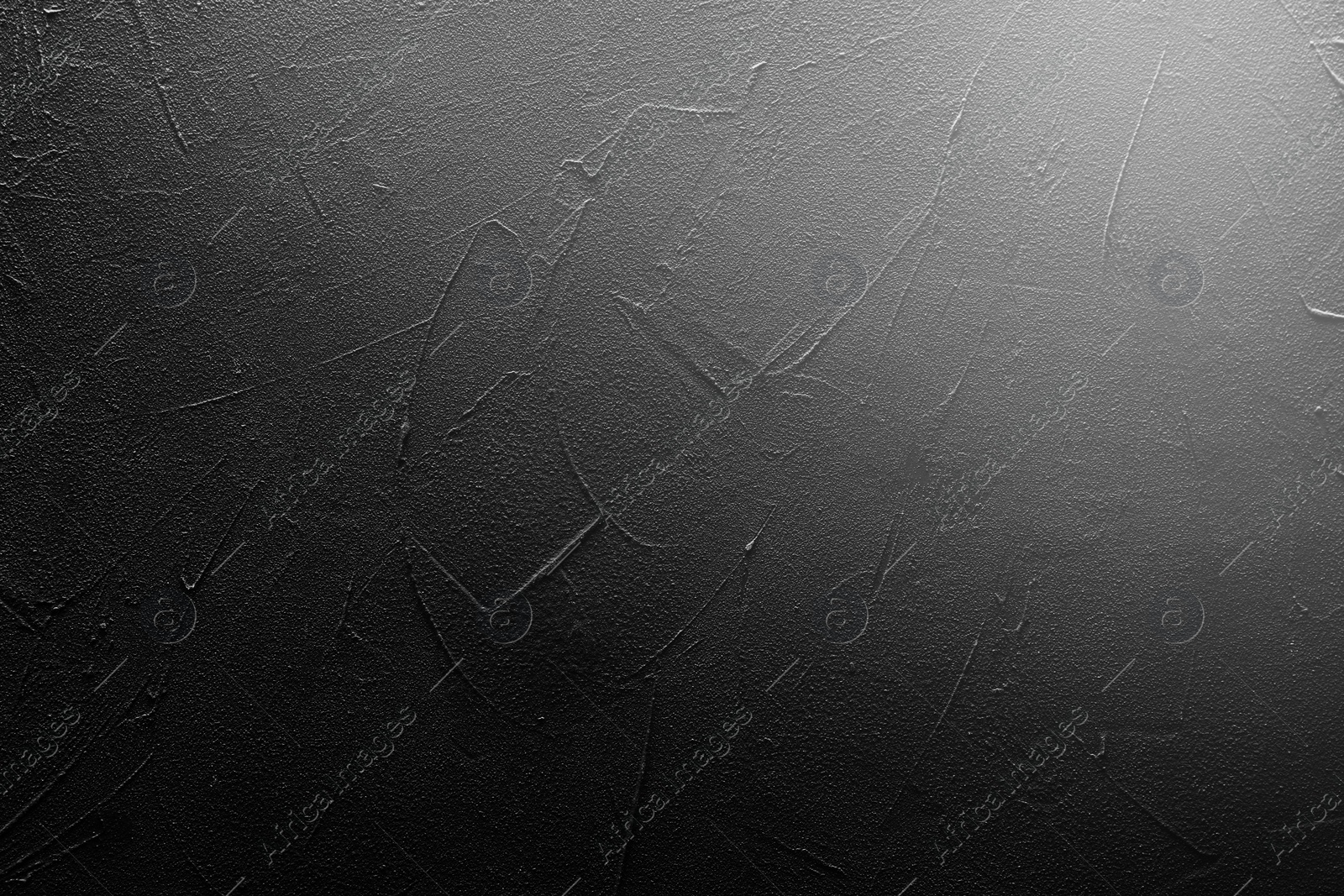 Image of Texture of dark textured surface spot of light as background, top view