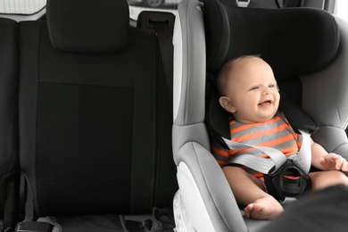 Photo of Little baby in child safety seat inside of car