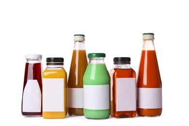 Photo of Tasty drinks in bottles with blank labels on white background. Mock up for design