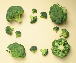 Fresh broccoli on beige background, flat lay. Space for text