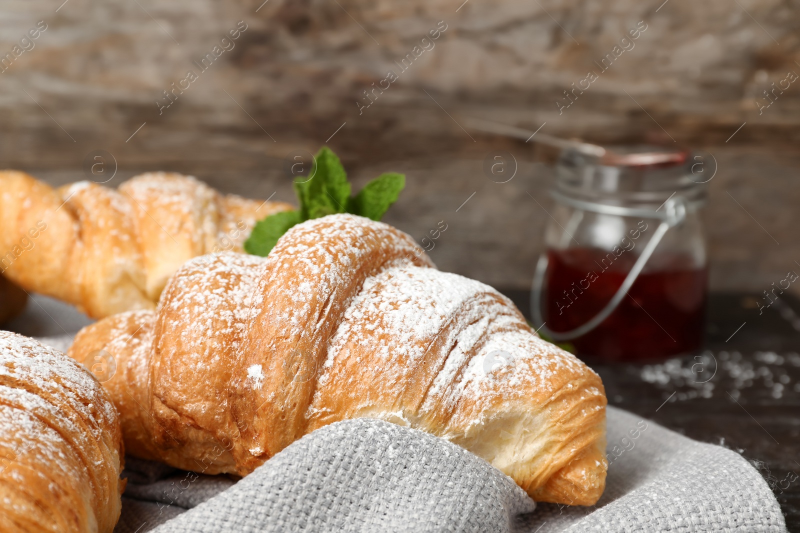 Photo of Tasty croissant with sugar powder, closeup