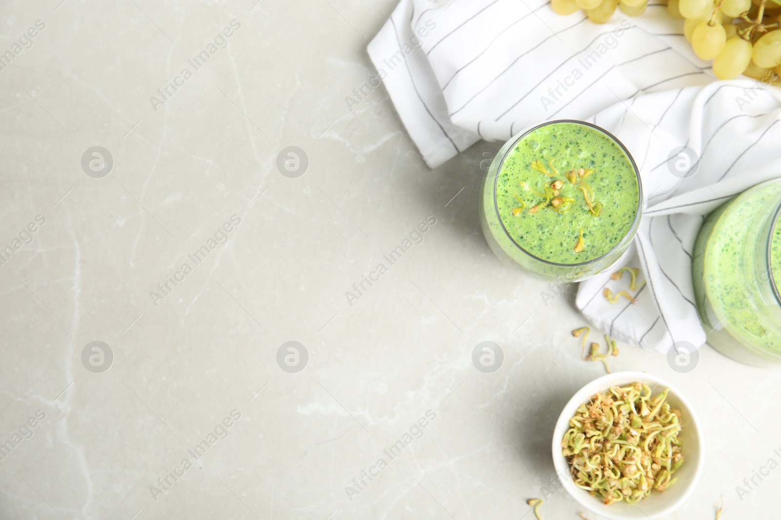 Photo of Flat lay composition with green buckwheat smoothie on light grey marble table, space for text