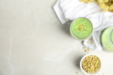 Photo of Flat lay composition with green buckwheat smoothie on light grey marble table, space for text