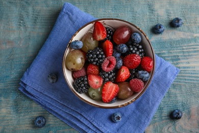 Photo of Fresh tasty fruit salad on blue wooden table, flat lay