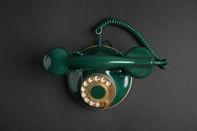 Photo of Elegant vintage green telephone on black background, top view