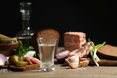 Photo of Cold Russian vodka with snacks on wooden table