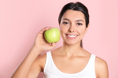 Photo of Young woman with healthy teeth and apple on color background