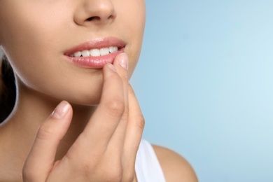 Photo of Young woman with sexy lips on color background, closeup