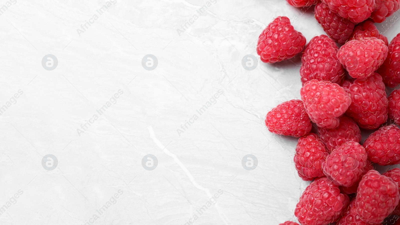 Photo of Delicious fresh ripe raspberries on light marble table, flat lay. Space for text