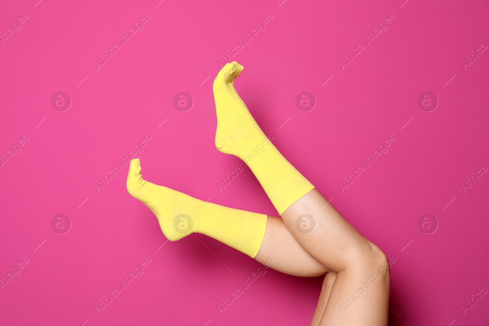 Photo of Woman wearing bright socks on color background