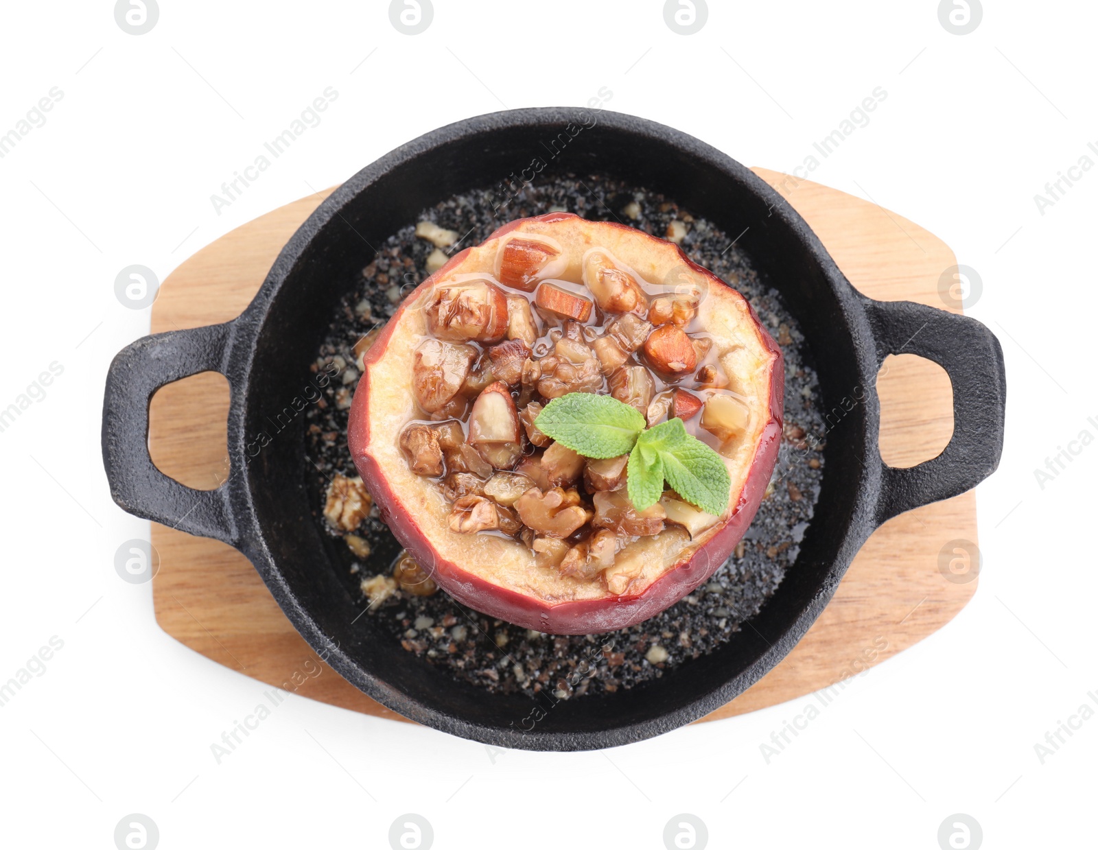 Photo of Tasty baked apple with nuts, honey and mint in baking dish isolated on white, top view