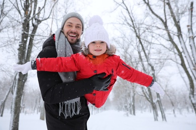 Photo of Father with his child having fun outside on winter day. Christmas vacation