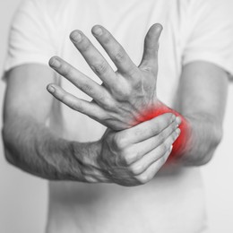 Image of Man suffering from rheumatism, closeup. Black and white effect with red accent in painful area