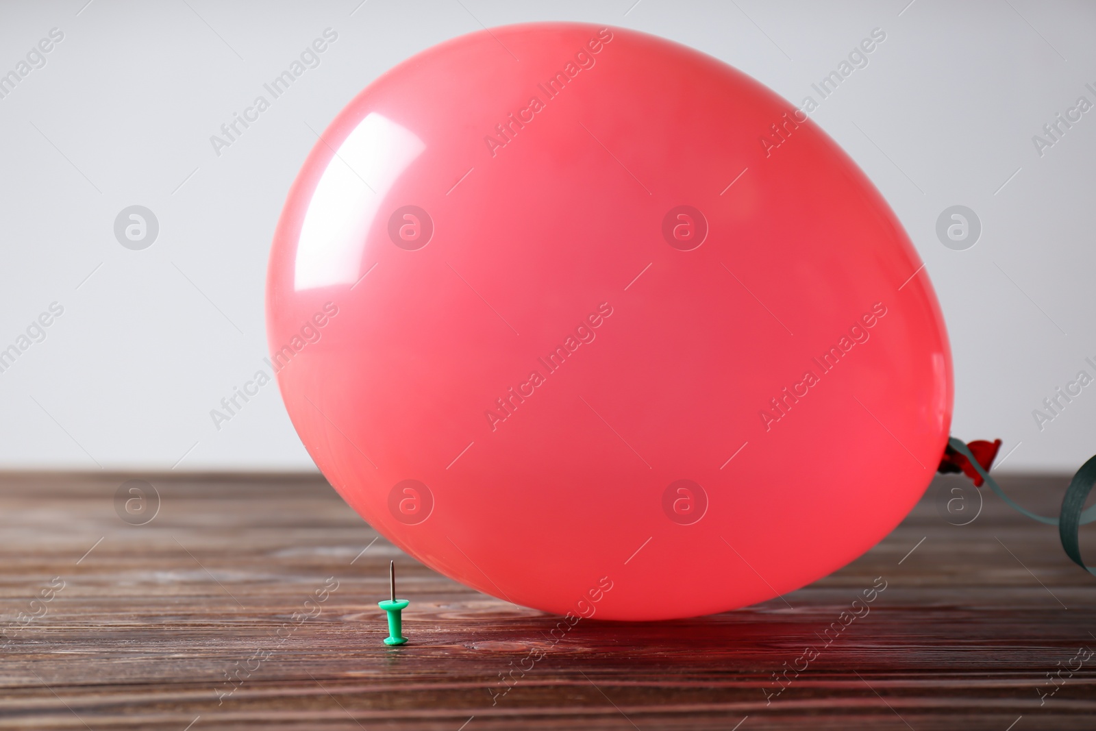 Photo of Color balloon and pin on table against white background