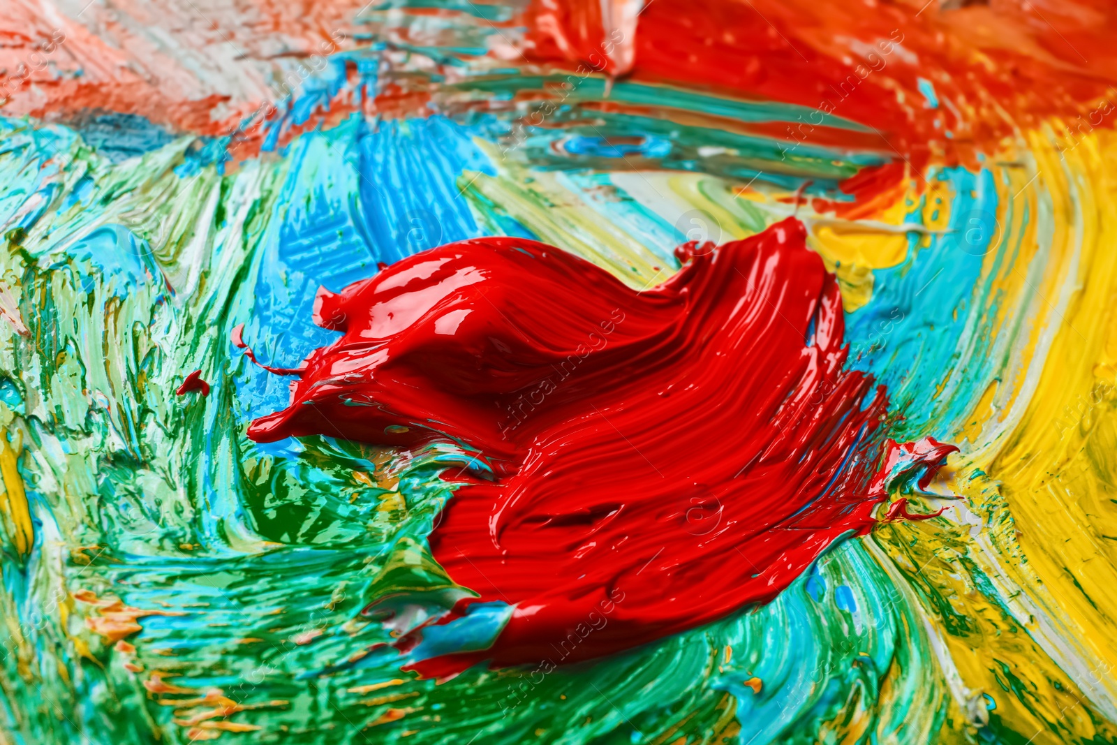 Photo of Closeup view of artist's palette with mixed bright paints as background