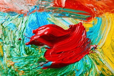 Closeup view of artist's palette with mixed bright paints as background