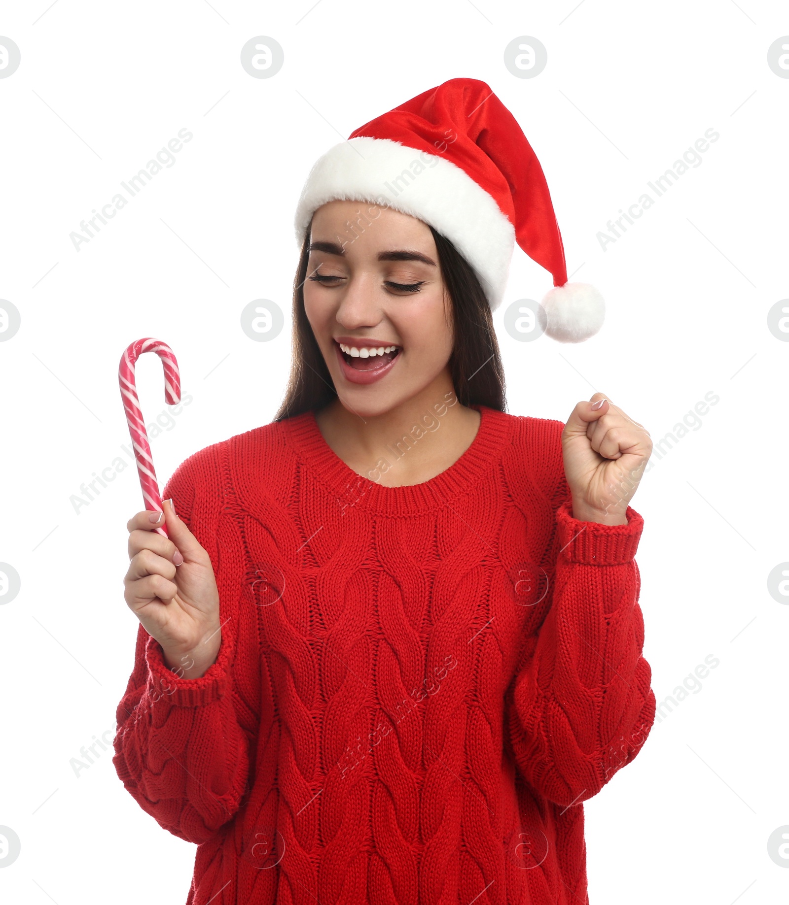 Photo of Young woman in red sweater and Santa hat holding candy cane on white background. Celebrating Christmas