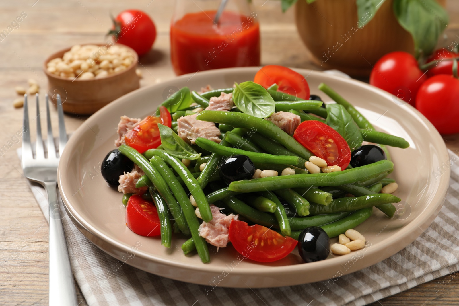 Photo of Tasty salad with green beans served on wooden table