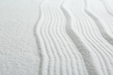 Photo of Zen rock garden. Wave pattern on white sand, closeup