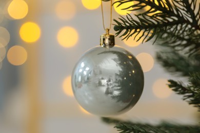 Photo of Closeup of beautiful bauble hanging on Christmas tree. Space for text